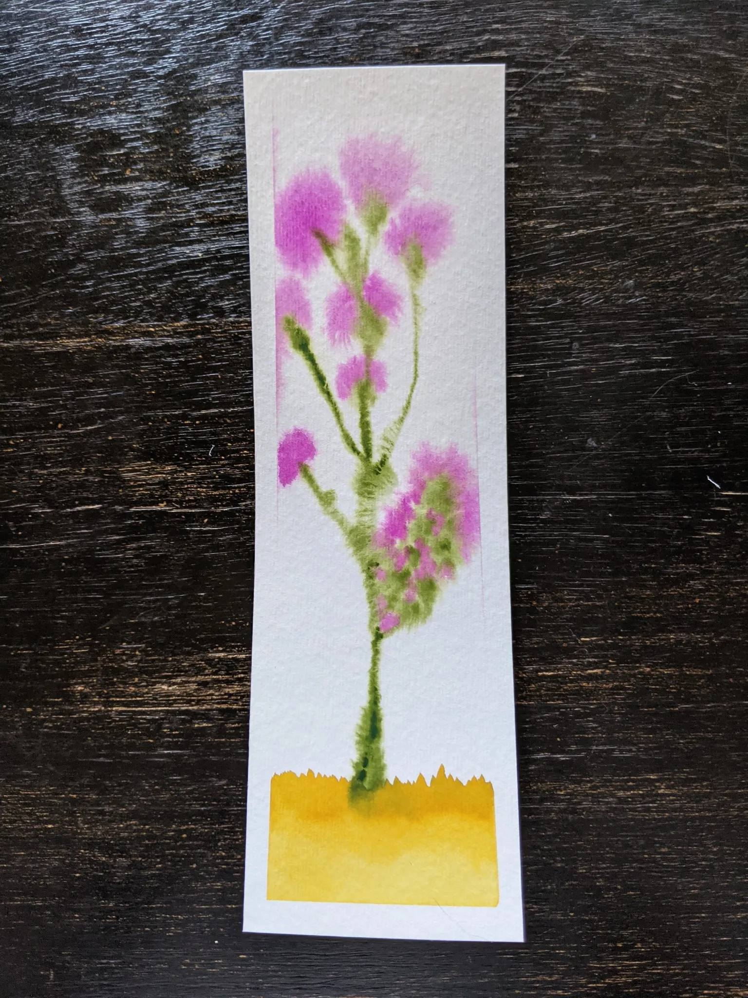 A bookmark with a watercolor painting of a purple thistle plant.